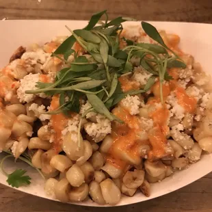 a plate of pasta with cheese and greens