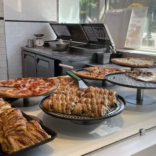 a variety of pizzas and pastries on display