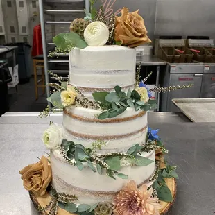 a three tiered cake decorated with fresh flowers