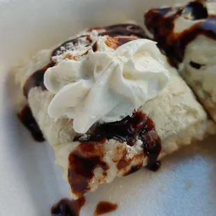 a piece of ice cream with chocolate sauce and whipped cream