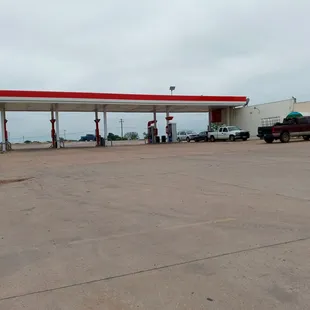 Large parking lot. This is the side of the gas station. Back road attached going into town or the highway crossing.