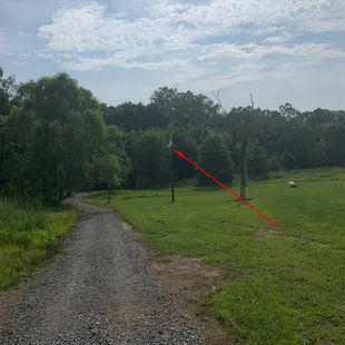 a dirt road with a red arrow