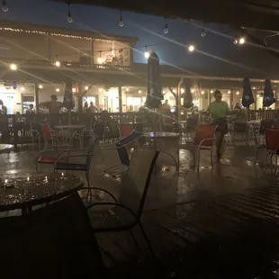 people sitting at tables with umbrellas