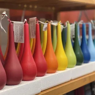 a row of colorful vases on a shelf