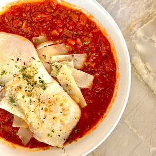 Liquid Gold Baked Eggs. It's essentially a bowl of marinara sauce topped with two over easy eggs and sourdough bread for dipping.