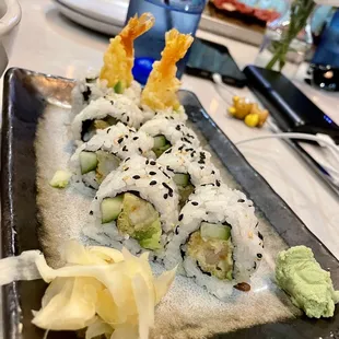 a plate of sushi with shrimp and avocado
