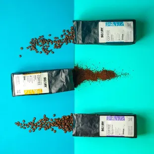 three bags of coffee beans spilling out of them