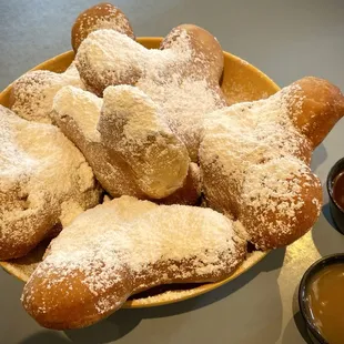 Six fresh Mickey Beignets ($11.29) with salted caramel and chicory-chocolate sauces.