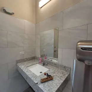 a bathroom with a sink and a soap dispenser