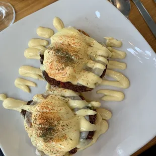 two eggs benedicts on a white plate