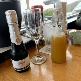 a bottle of champagne and a glass of orange juice