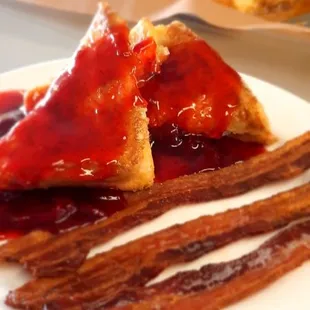 Strawberry stuffed French toast side of bacon with our fresh baked daily Carmel rolls in the back!