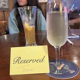 a woman sitting at a table with a glass of wine