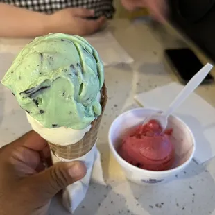 Double scoop of ice cream one white pistachio one mint and chip on a waffle cone
