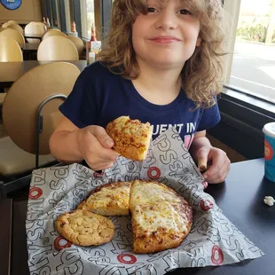 The kid enjoying the kid&apos;s pizza meal