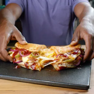 a man holding a large piece of pizza