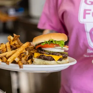 a person holding two plates of food