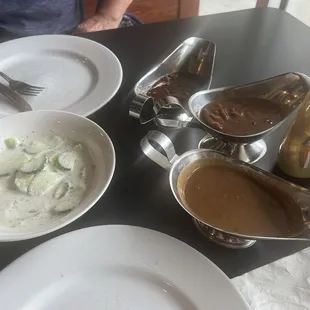 3 different sauces on plate and side of cucumbers