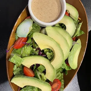 a salad with avocado, tomatoes and lettuce