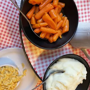 a bowl of macaroni and cheese and a bowl of carrots