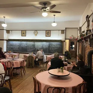 people sitting at tables in front of a blackboard