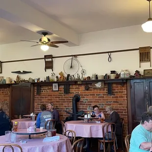 diners sitting at tables with pink tablecloths