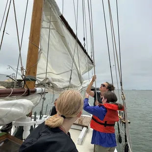 Helping raise the sail.