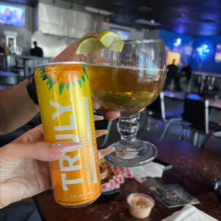 a person holding a can and a glass