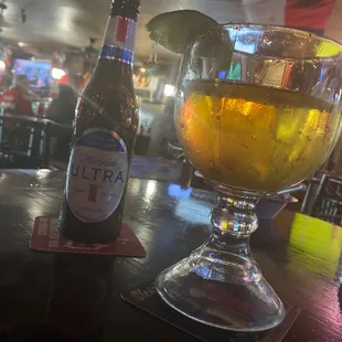 a glass of beer and a bottle of ultra