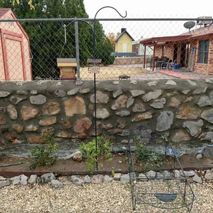 a garden with a stone wall