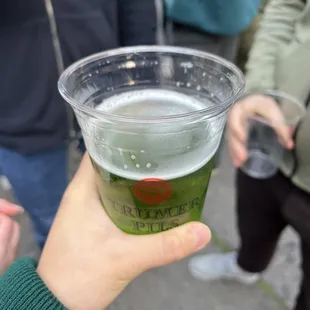 a person holding a cup of beer