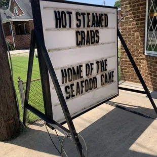 a sign that reads hot steamed crabs home of the seafood game
