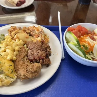 Left plate: Lasagna, meatloaf, chicken tender, sour cream potatoes, creamed peas, Mac n cheese.  Right plate: salad bar