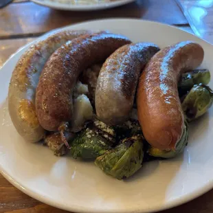 A mix of 4 German style sausages with warm potato salad and Brussel sprouts.