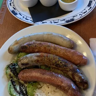 Wurst platter with assorted mustards, sides are Brussel sprouts and sauerkraut