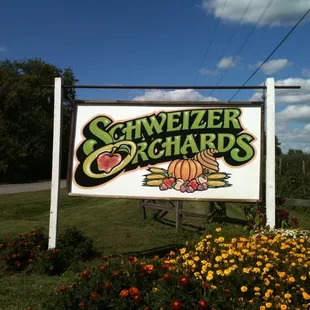 a sign in front of a field of flowers