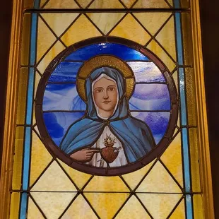 Stained glass window with an image of the Blessed Virgin Mary.