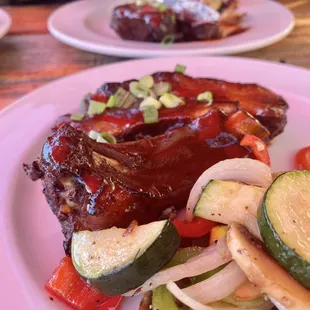 St. Louis baby back ribs half served two plates with fresh mixed veggies