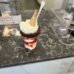 a cup of ice cream with a scoop sticking out of it