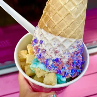 a hand holding a bowl of ice cream