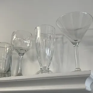 a collection of wine glasses on a shelf