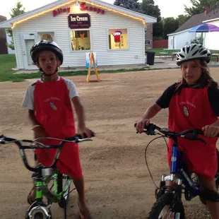 two children on bikes in front of a store