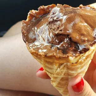a hand holding a cone of ice cream