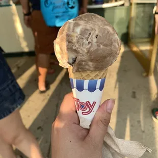 a hand holding a cone of ice cream