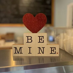 a be mine sign with a heart