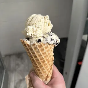 a hand holding a cone of ice cream