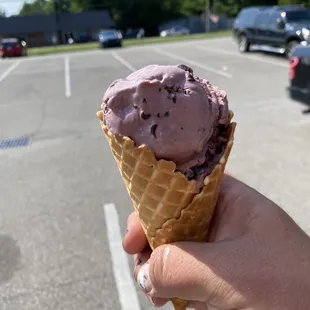 a hand holding an ice cream cone