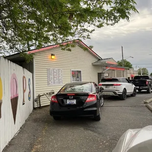 a car parked in front of a small ice cream shop