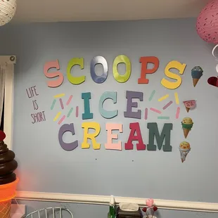 a wall with a sign that says scoops and ice cream