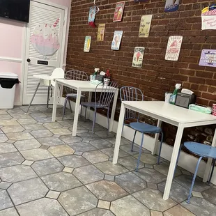 tables and chairs in a room with a brick wall